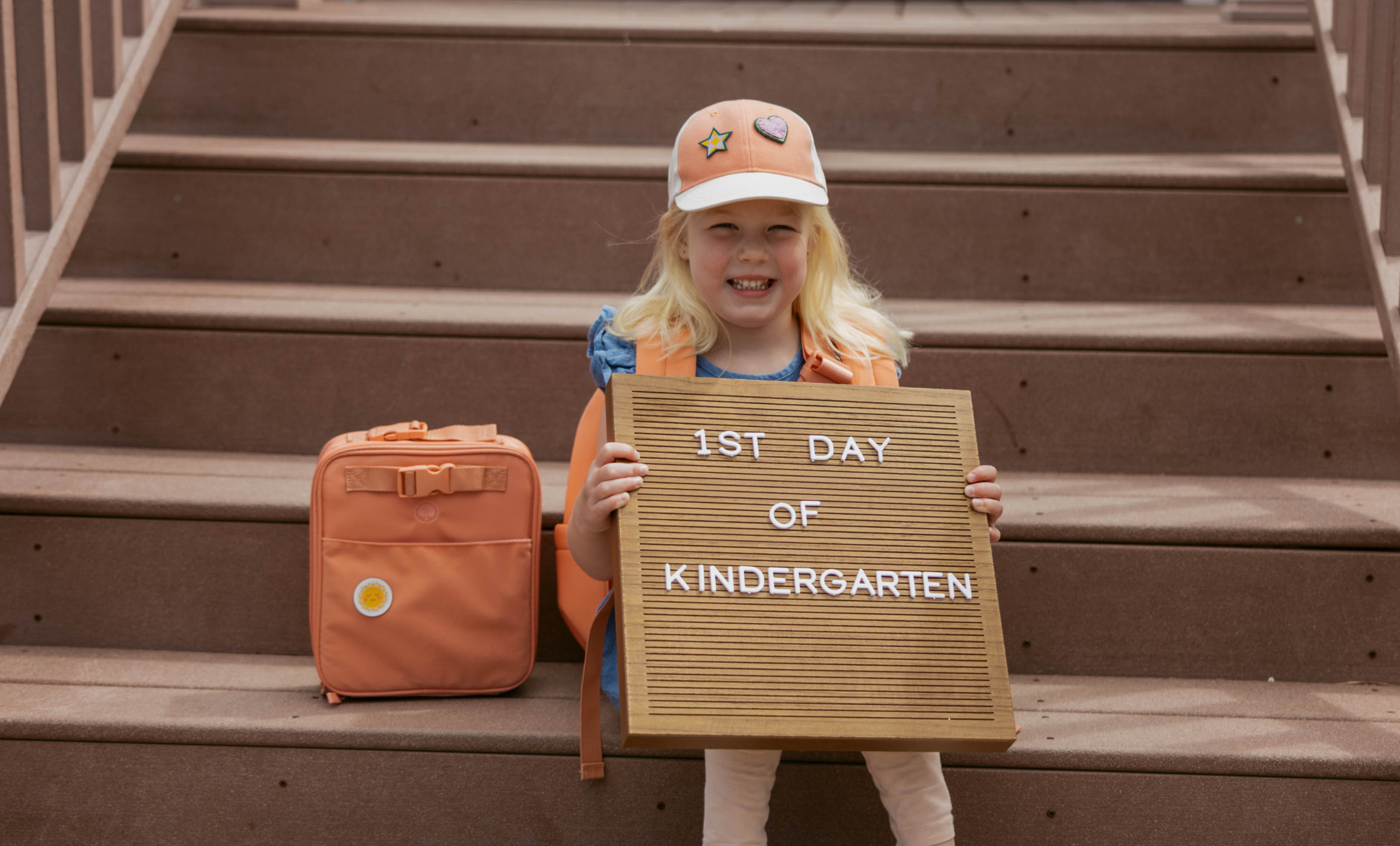 Child wearing a kids backpack while sitting outside